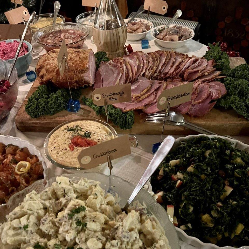 Julbord med uppskuren julskinka, sill, sallader och tillbehör